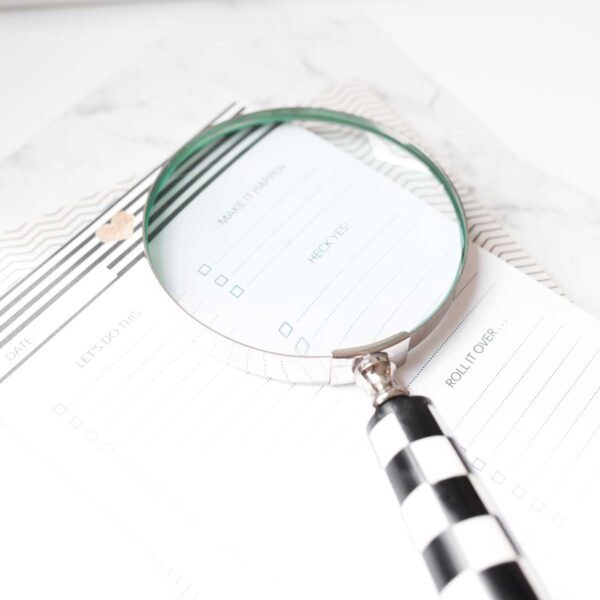 magnifying glass set upon a planner