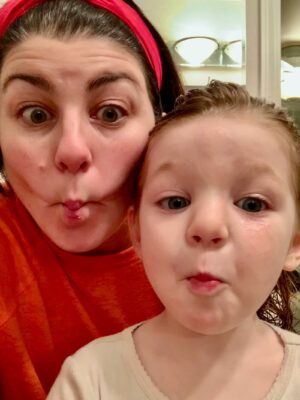 Mom and daughter making faces in the mirror