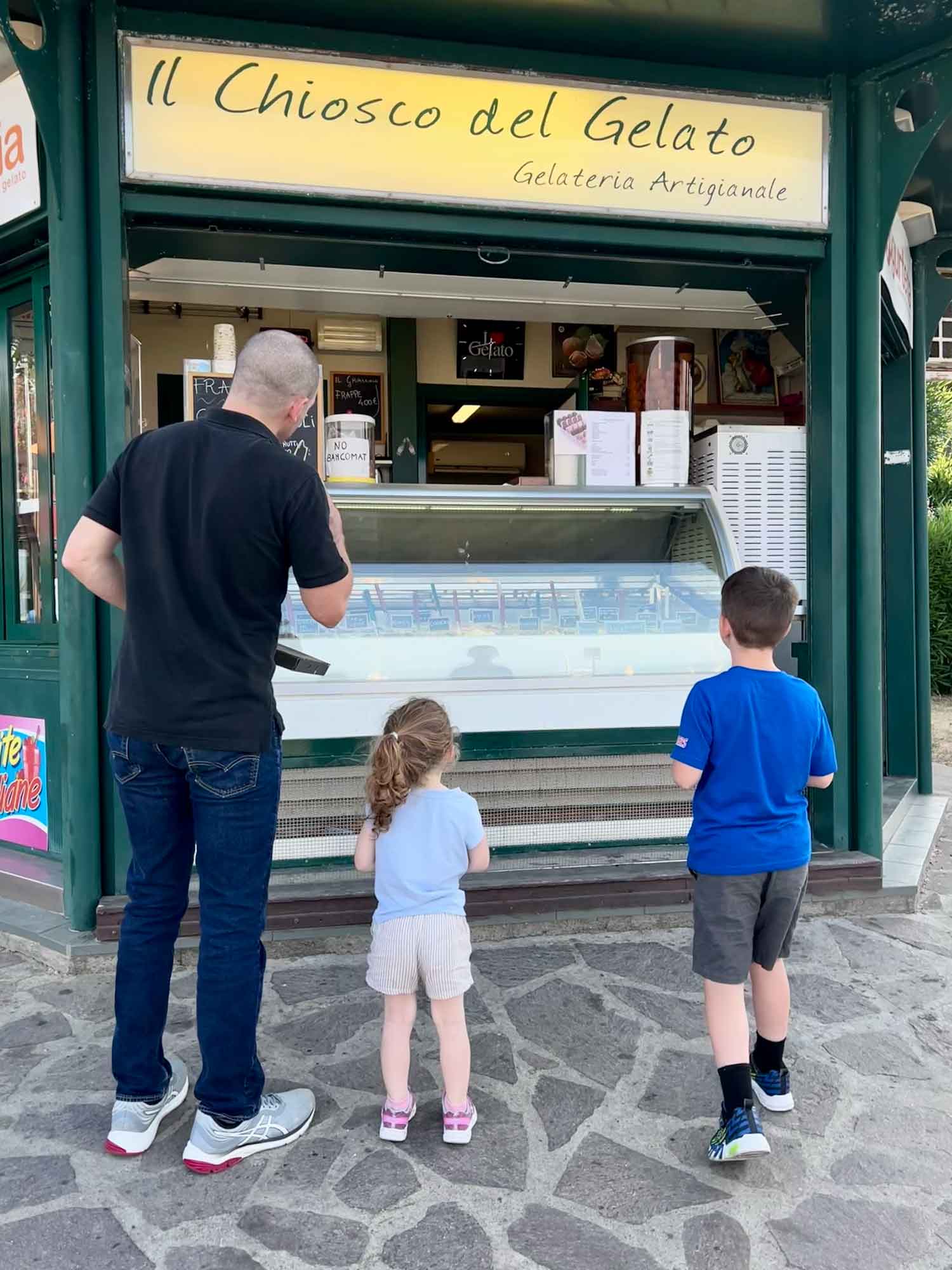 Dad and kids waiting at ice cream kiosk