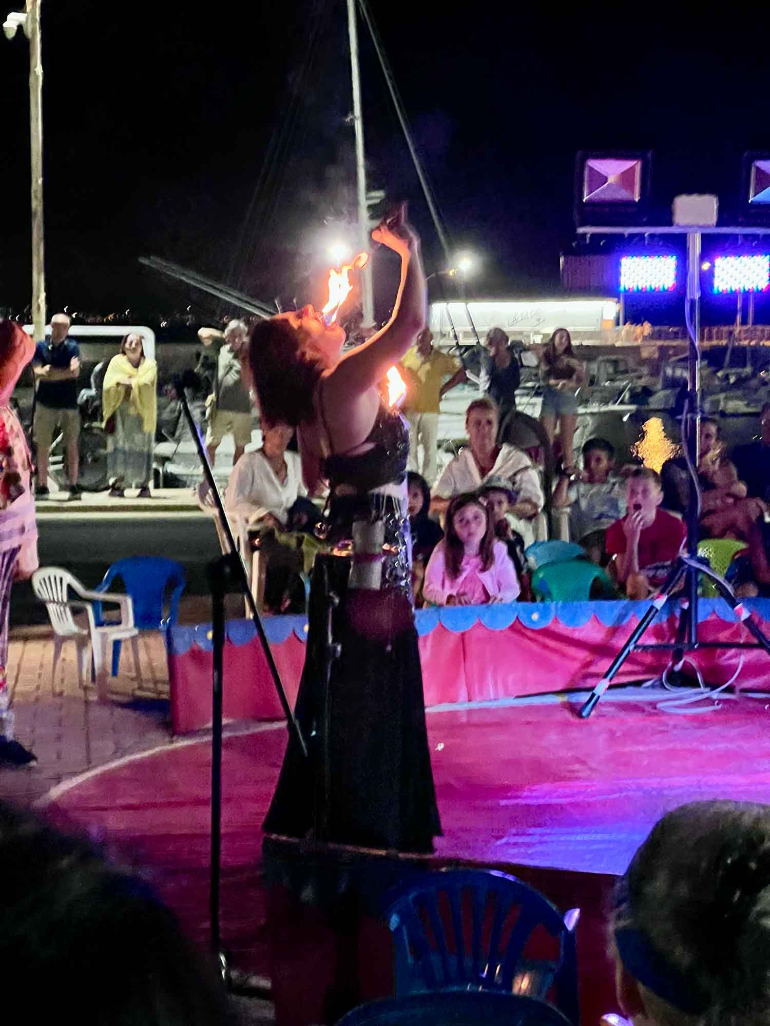 A woman at a carnival breathes fire