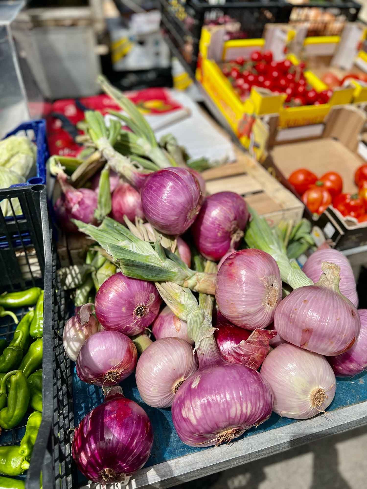 a bunch of fresh red onions at a market