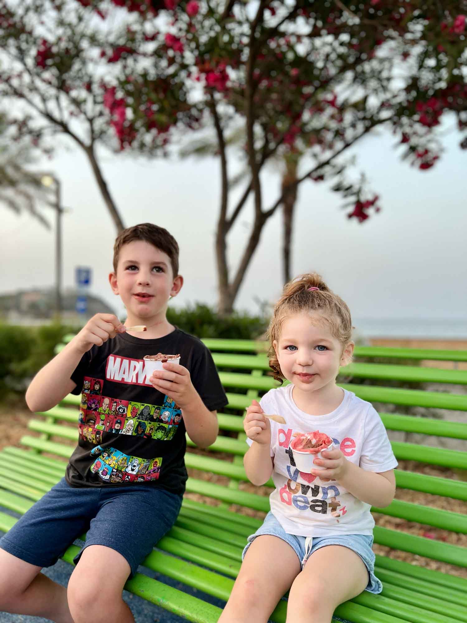 two kids on a bench eating ice cream