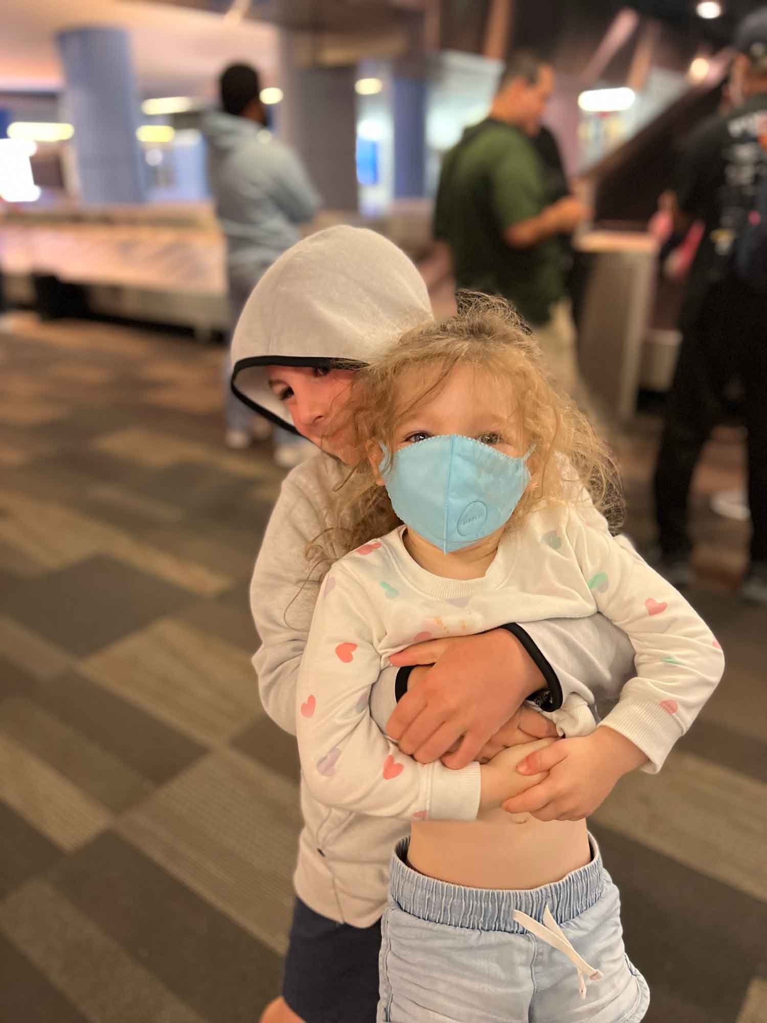 Brother picking up little sister in the airport