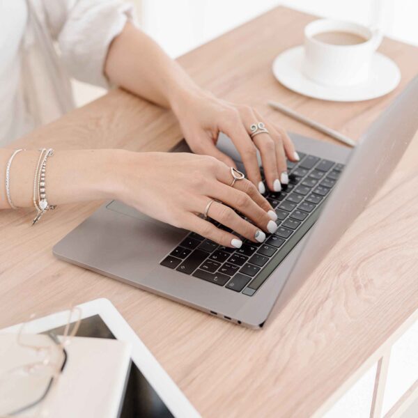 female hands hovering over a laptop keyboard