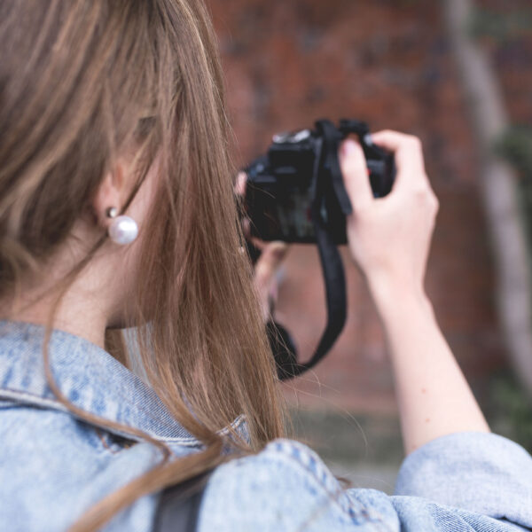 over the shoulder view of woman taking a photo with digital camera